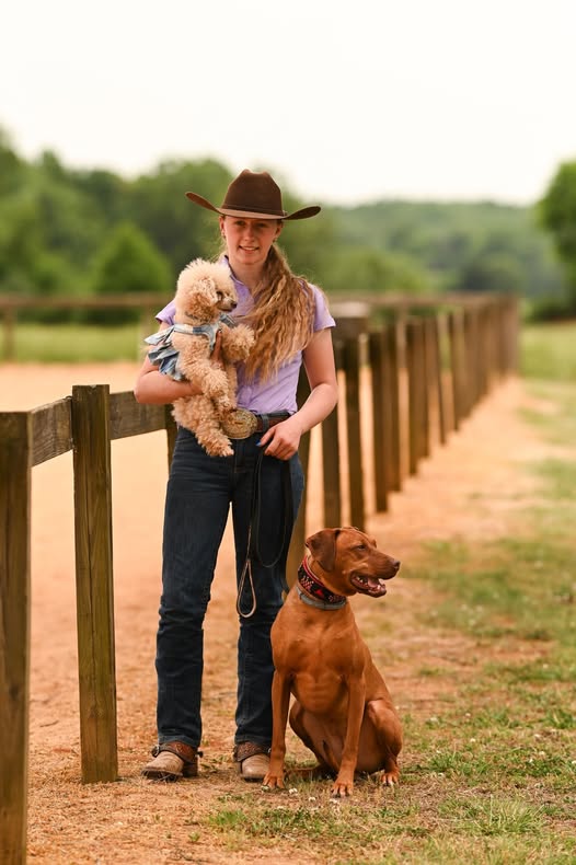Abagail Lee, Bather and Receptionist at Paw Prints Etc LLC, with Callie the poodle and Savage the Rhodesian Ridgeback