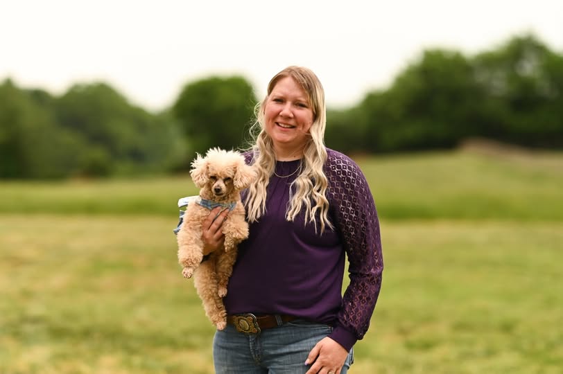 Rebekah Lee, Owner and Certified Pet Stylist at Paw Prints Etc LLC, holding her toy poodle Callie